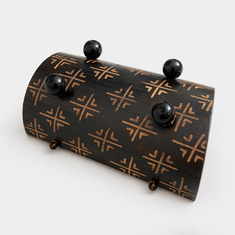Bottom of the decorative wooden gamelan glockenspiel showcasing the geometric pattern and black feet on a white studio background