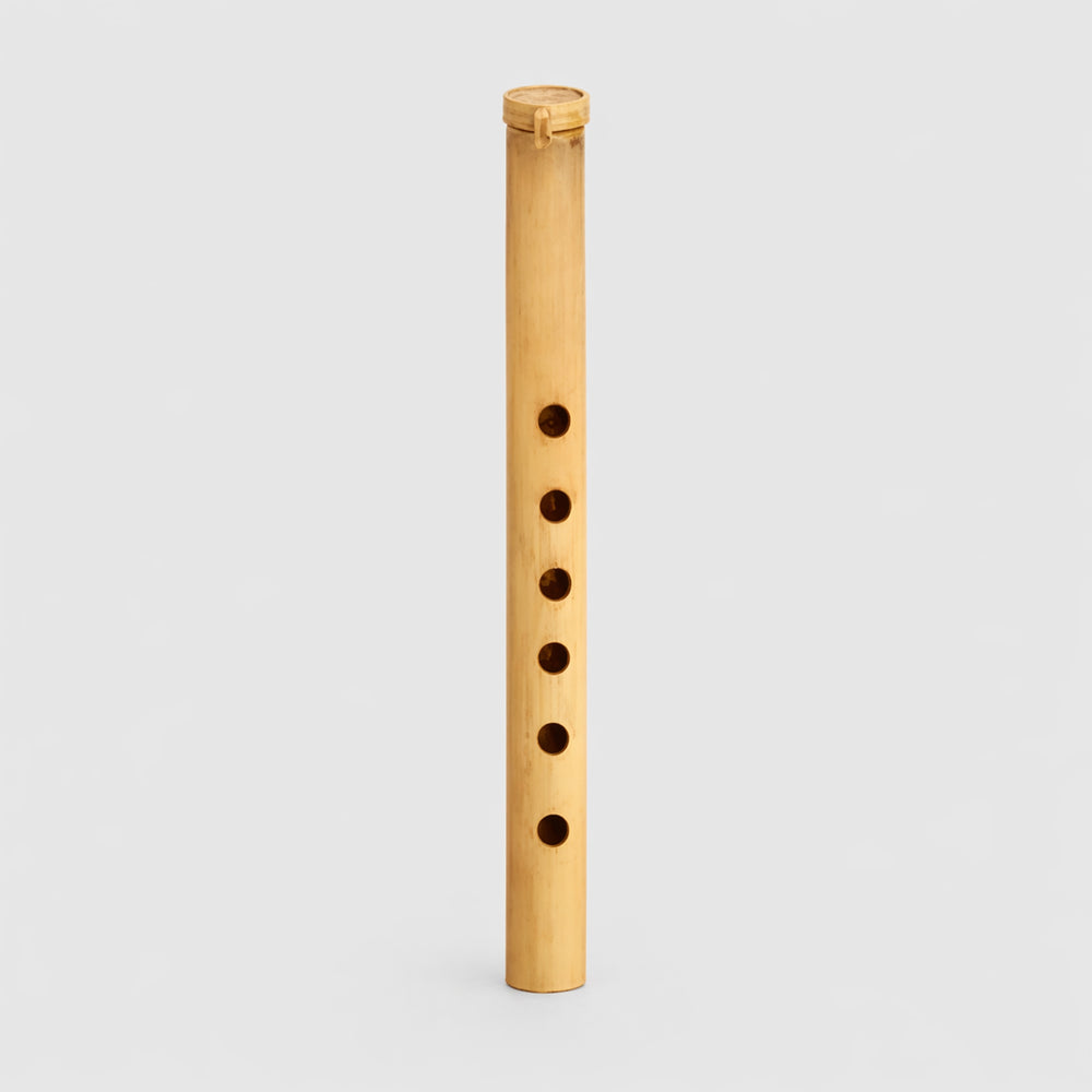 Small traditional Gamelan Suling bamboo flute from Indonesia on a light gray studio background