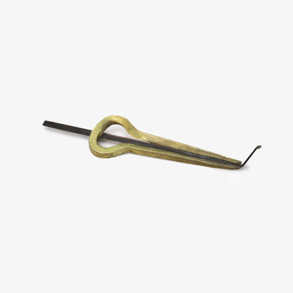 Small brass mouth jaw harp on a grey studio background