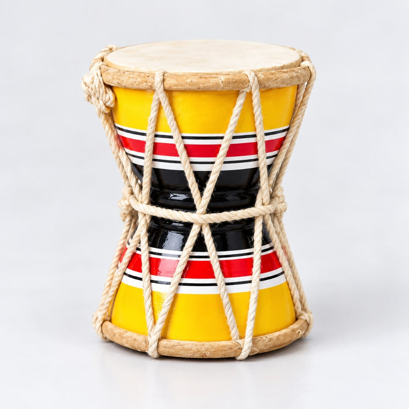 Yellow red and black traditional indian damaru drum on a light grey studio background