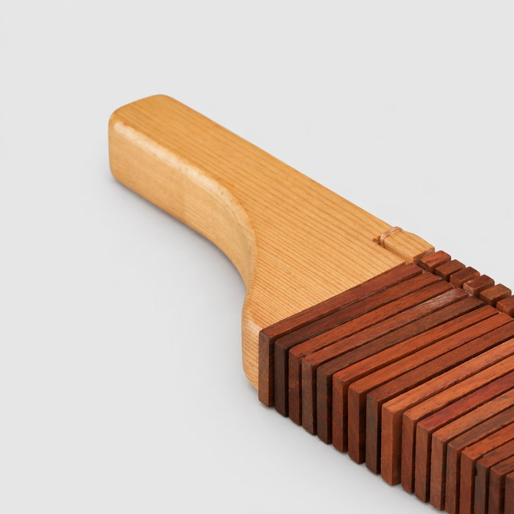 Close-up of the Matsu Kokoriko showing the pine wood handle and rectangular percussive blocks.