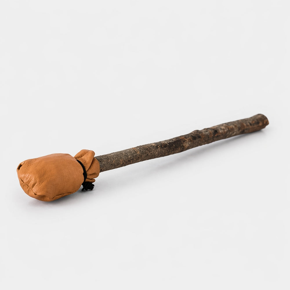 Dark brown leather shamanic drum beater with natural wooden stick handle on a studio white background