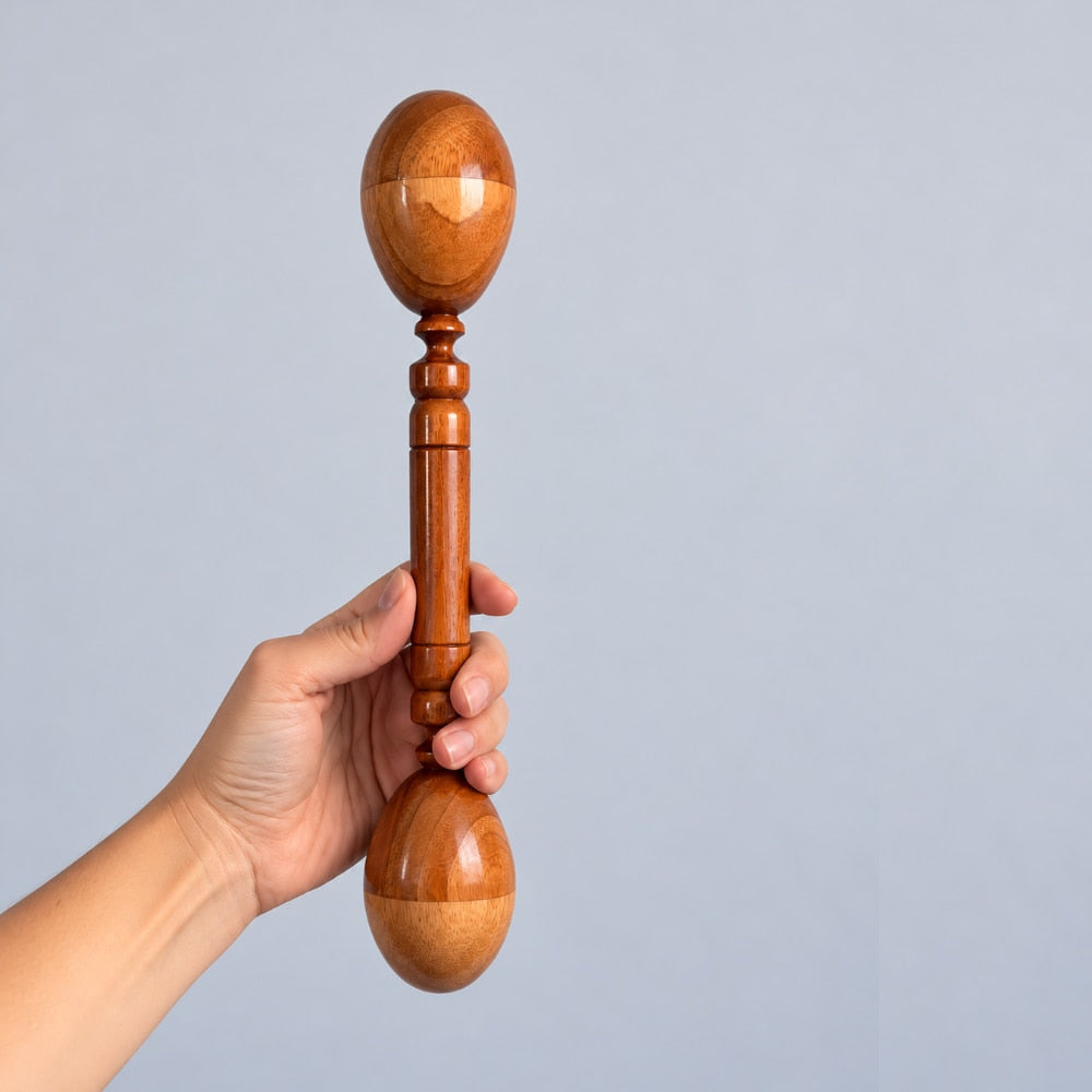 A hand holding a wooden double-ended egg shaker with a polished warm brown finish against a solid light gray background.
