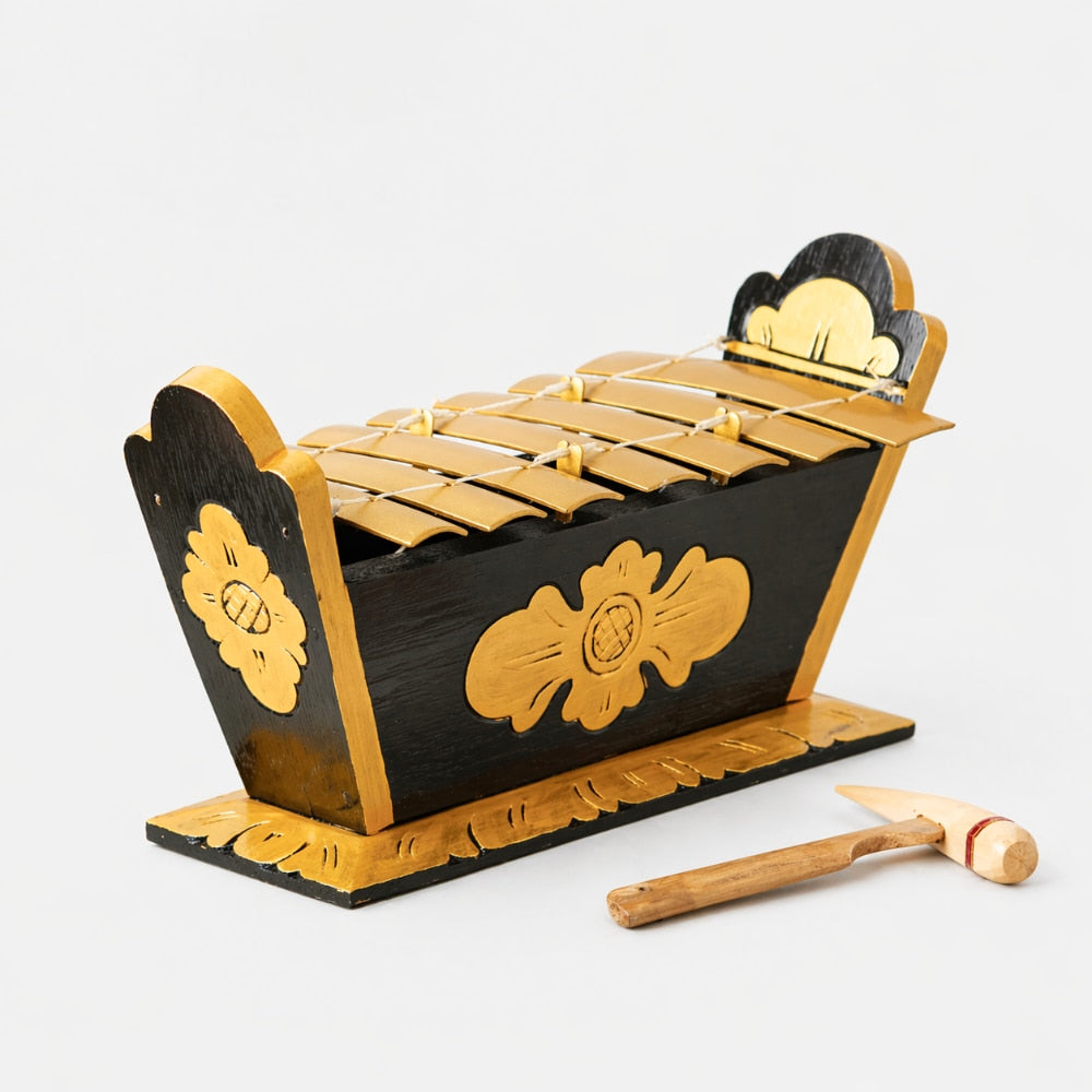 Wooden xylophone with decorative carvings on a white background