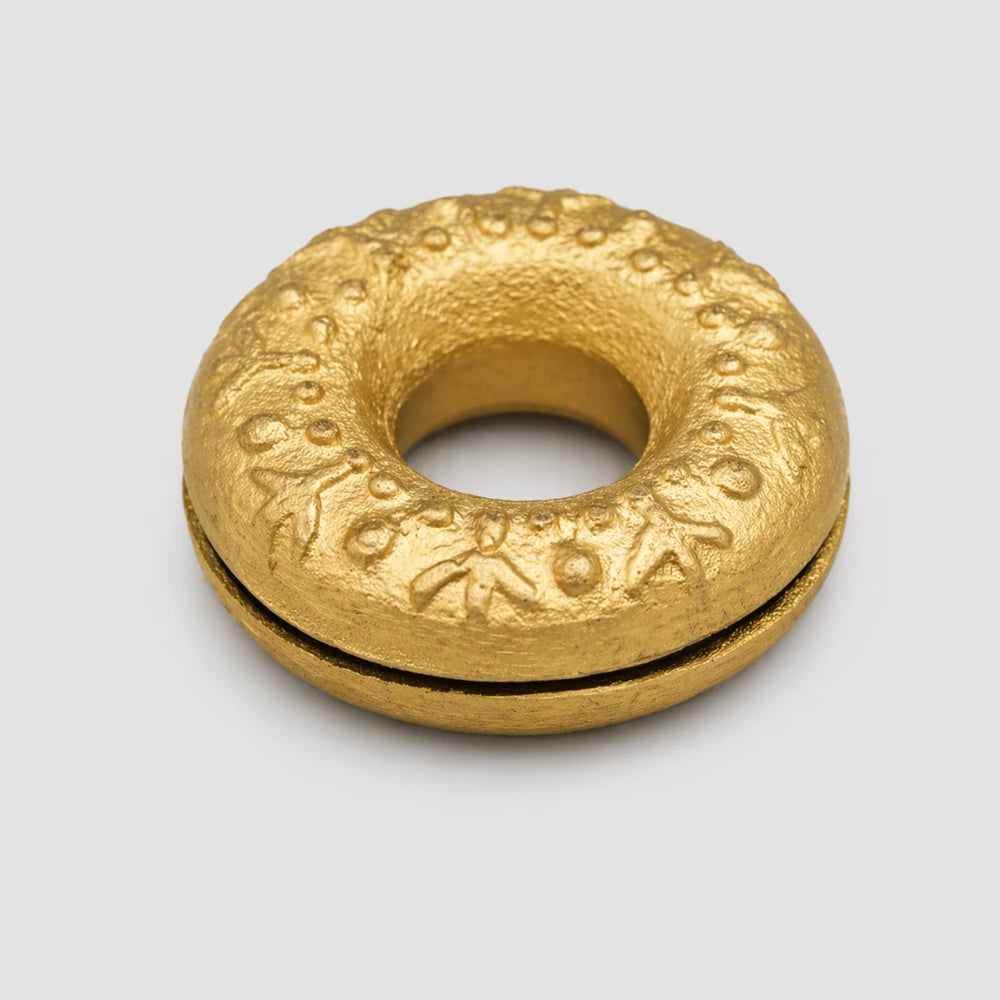 Top of the Brass Meo finger bell displaying intricate symbols.
