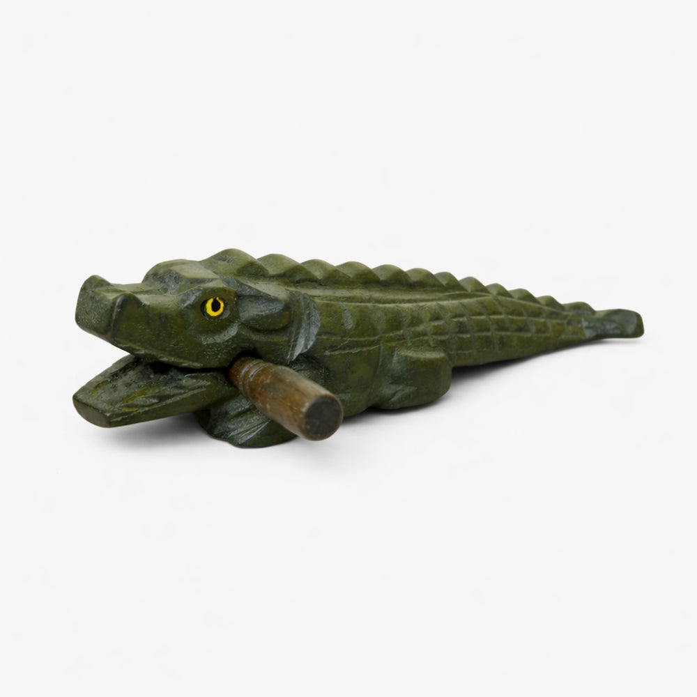 Solid Green crocodile guiro instrument with beater on a white background