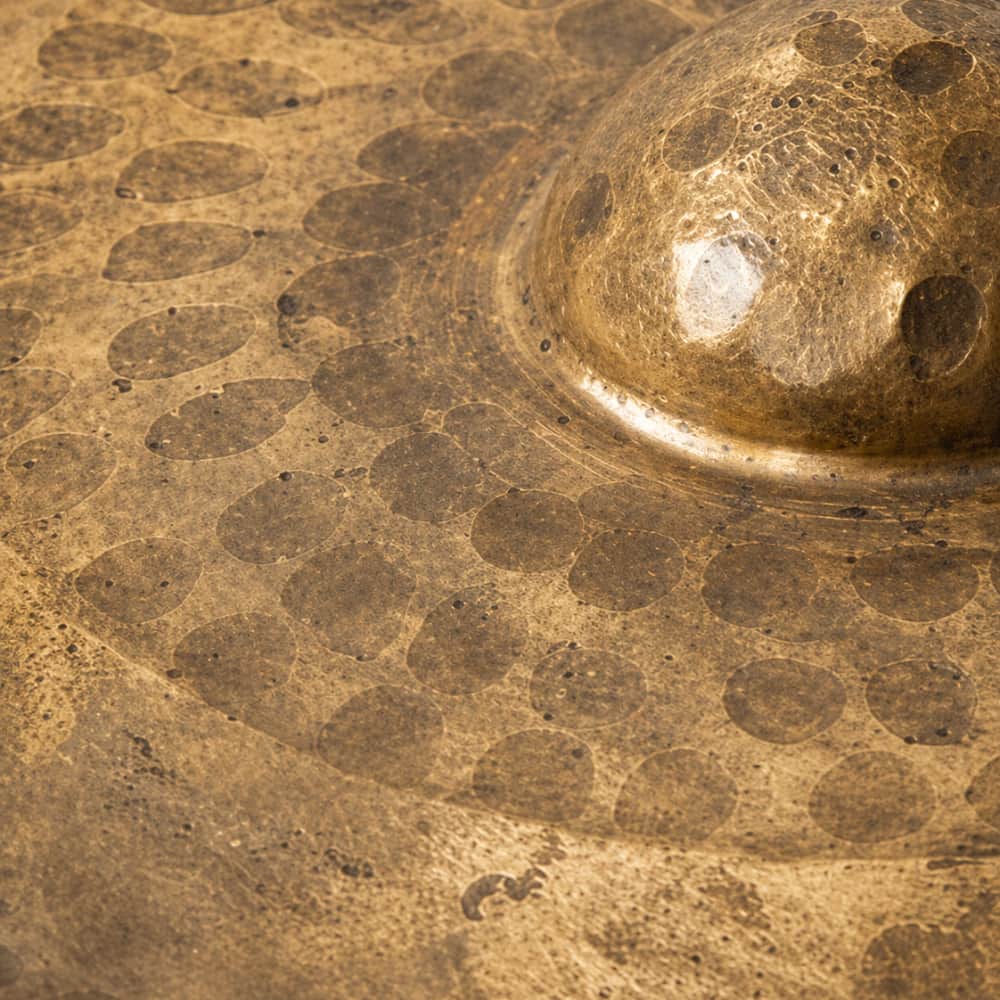 Close-up of a gongs textured gold surface with circular patterns 