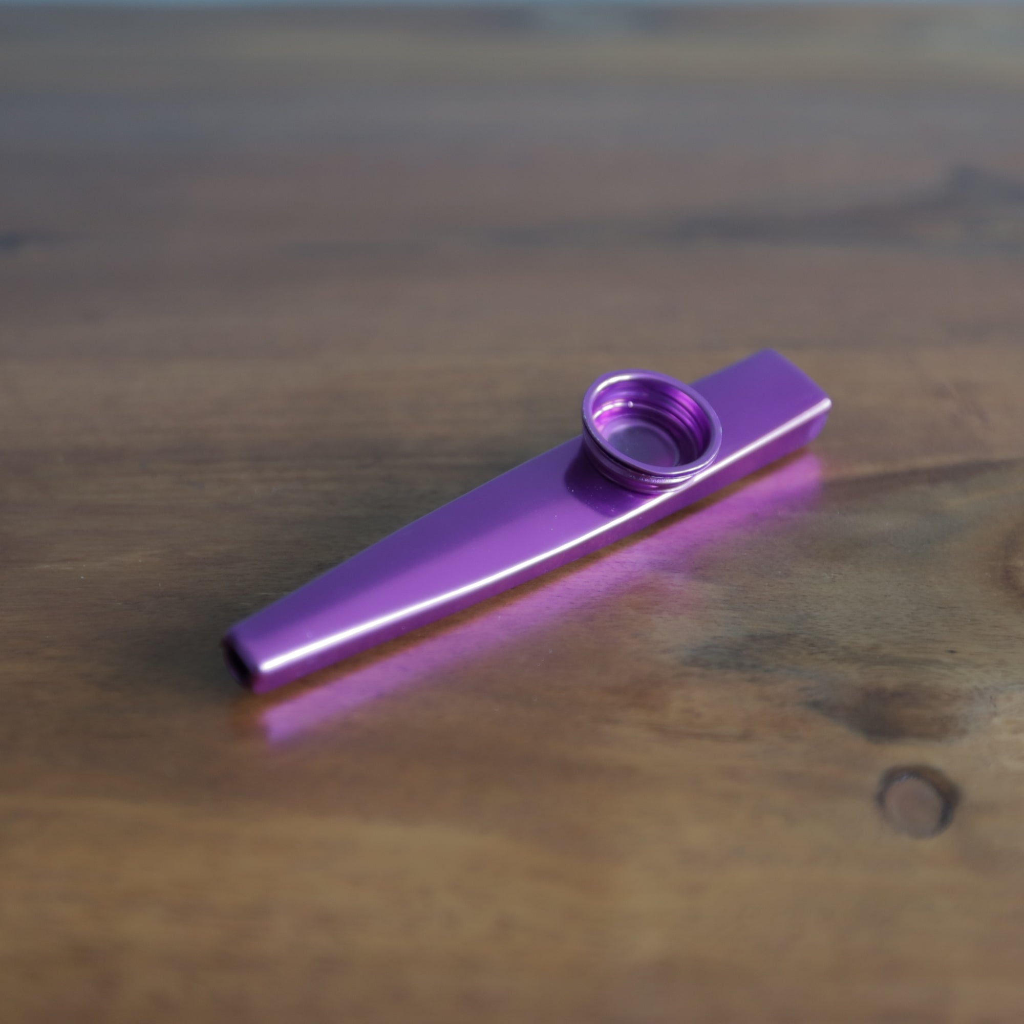 purple kazoo flute on sheesham table