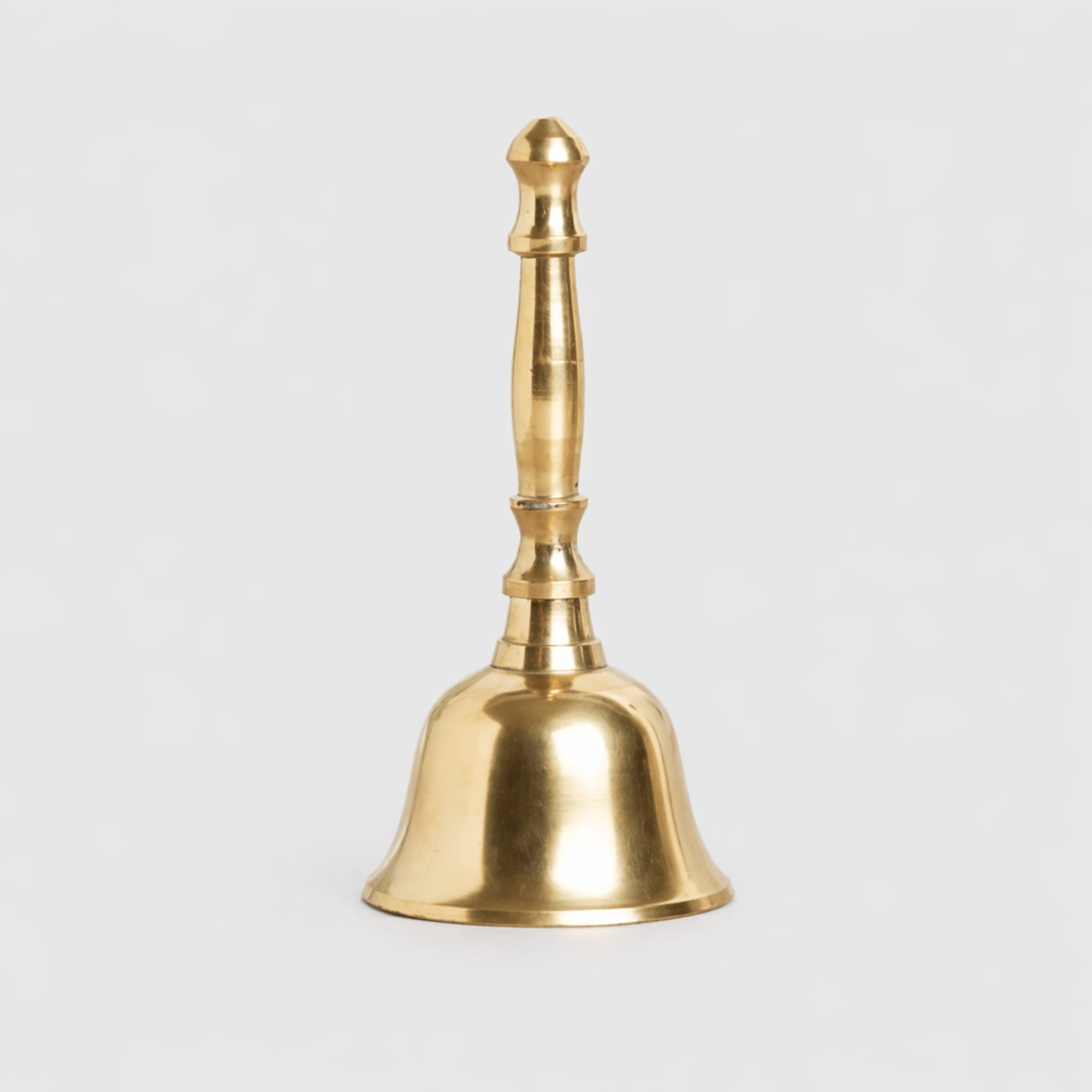 Gold bell on a light gray background