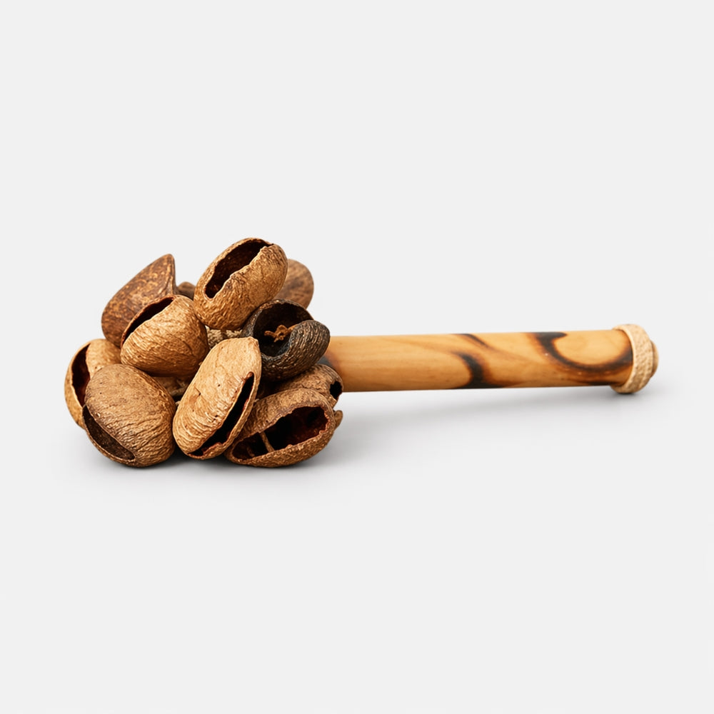 wooden raha husk shaker on bamboo stick with grey background 