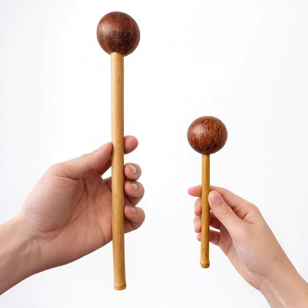 Two wooden rattles held by hands against a white background