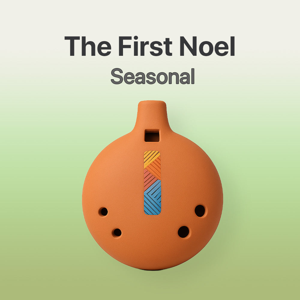 Ceramic ocarina with colorful design on a light green background, featuring 'The First Noel Seasonal' text.