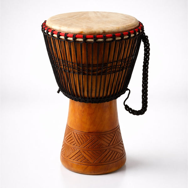 Wooden drum with a patterned base and red and black bead decoration on a white background