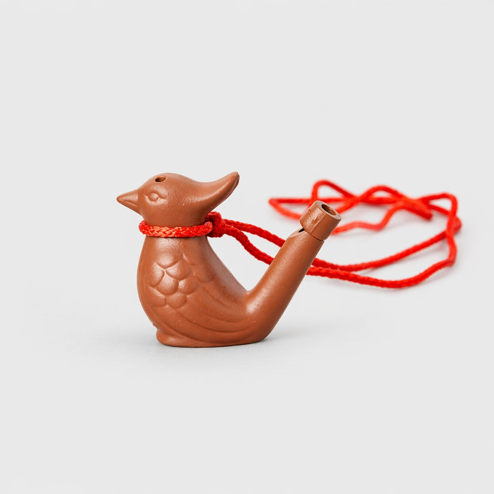Brown bird-shaped object with a red string on a white background