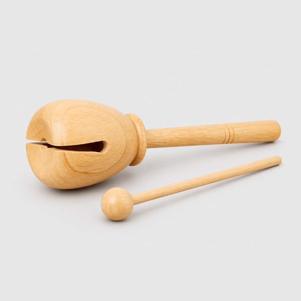 Wooden tone block with a handle on a light gray background