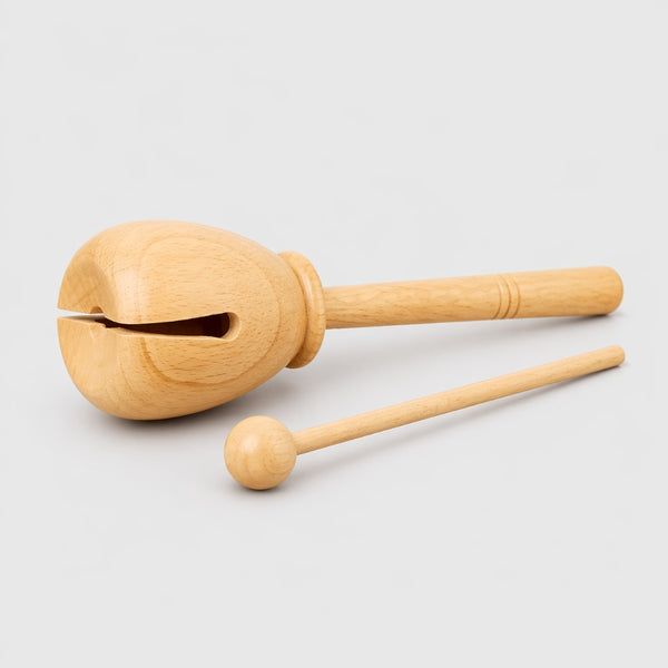 Wooden tone block with a handle on a light gray background