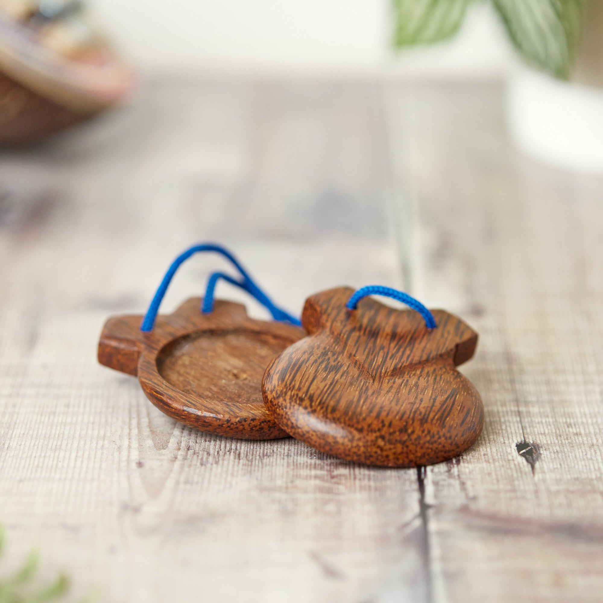carved coconut wood castanets on blue rope