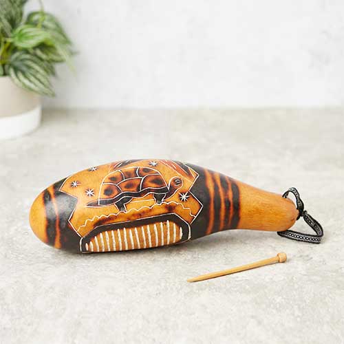 carved painted gourd with rasp stick