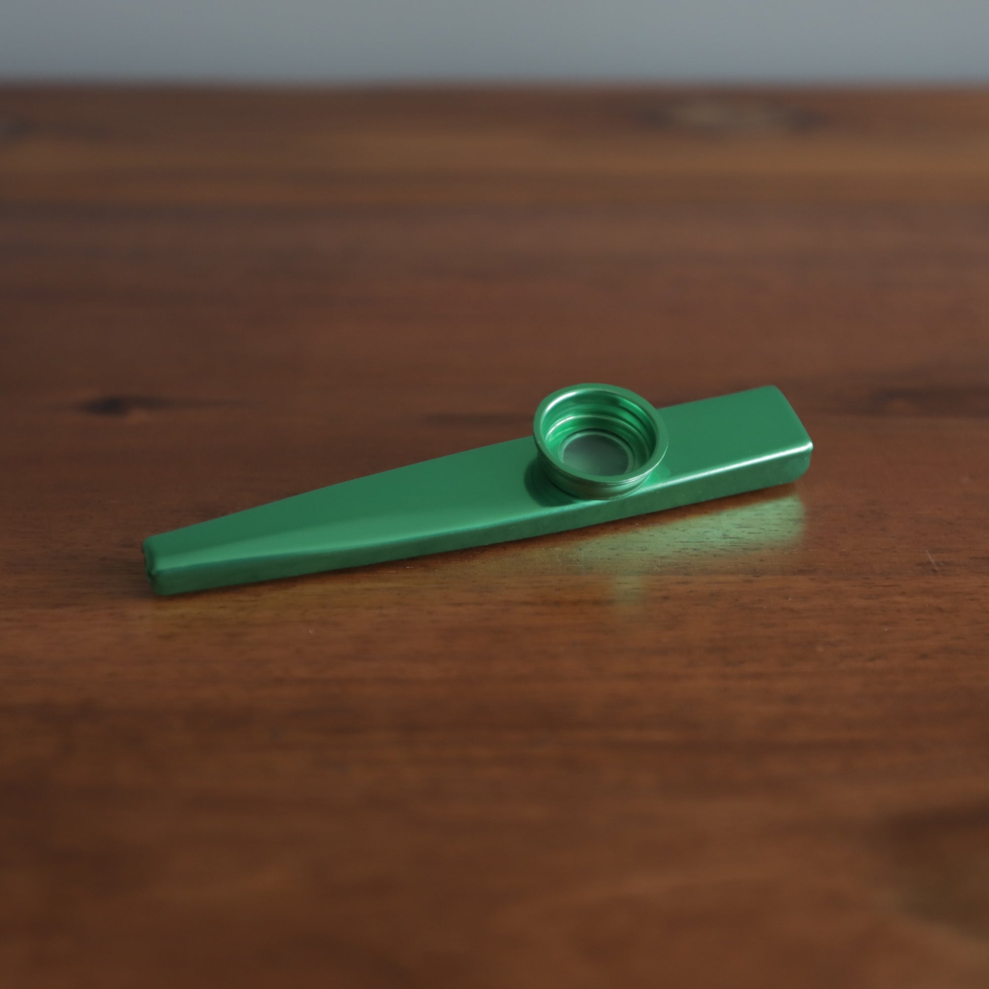 green kazoo flute wooden table